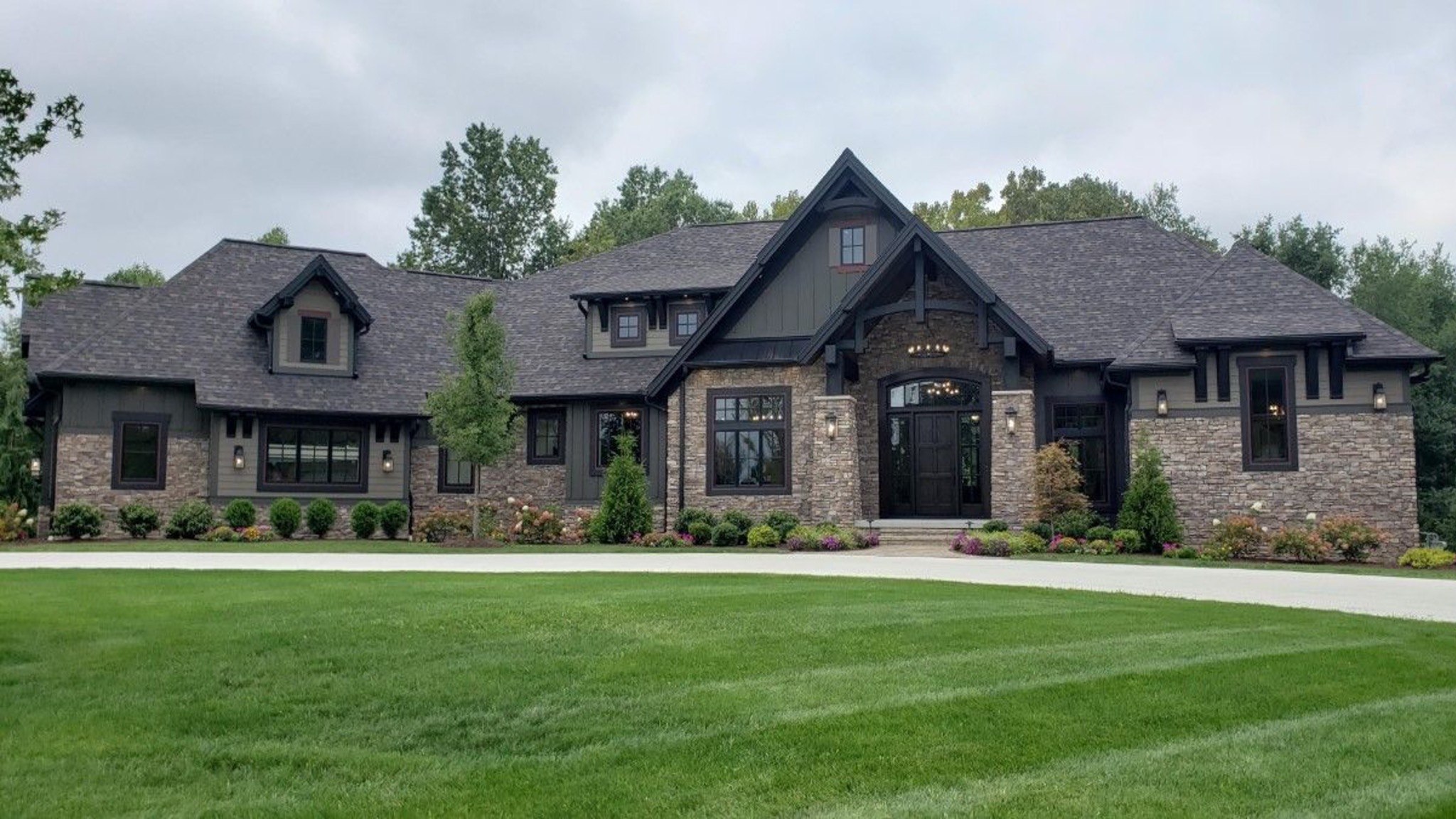 Completed stone custom home surrounded by trees