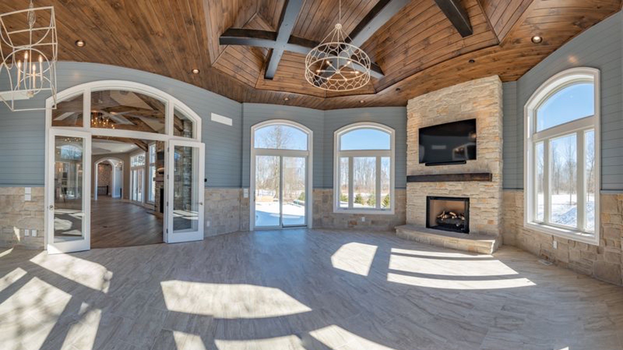 Finished great room with tall windows and fireplace