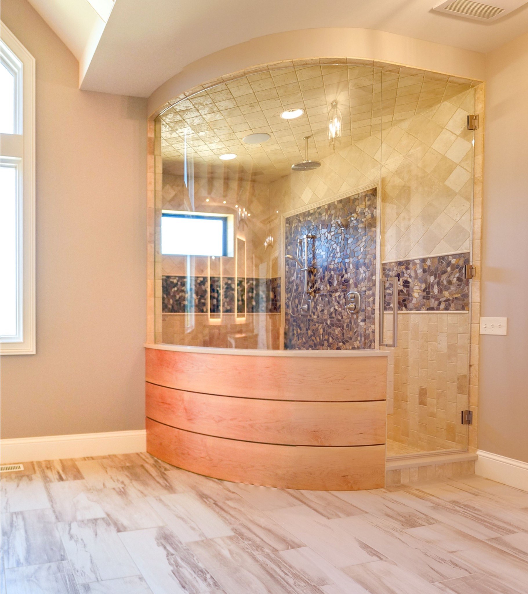 Custom bathroom shower with curved glass and detailed tilework